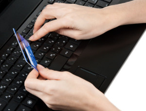 Feminine hands with bank card on keyboard